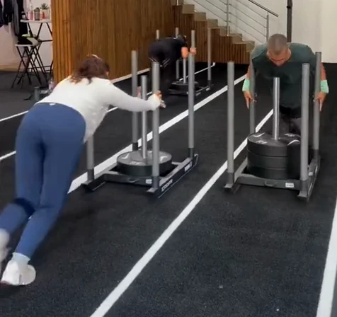 Deux adhérents poussent le sled sur la piste de Pornic Hybrid Training